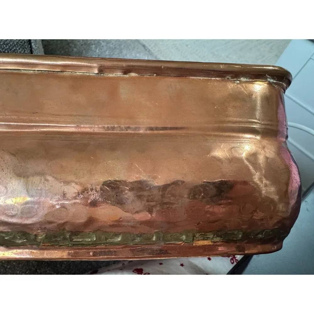 Antique hand-worked copper vessel visible dovetailed/soldered seam, hammered